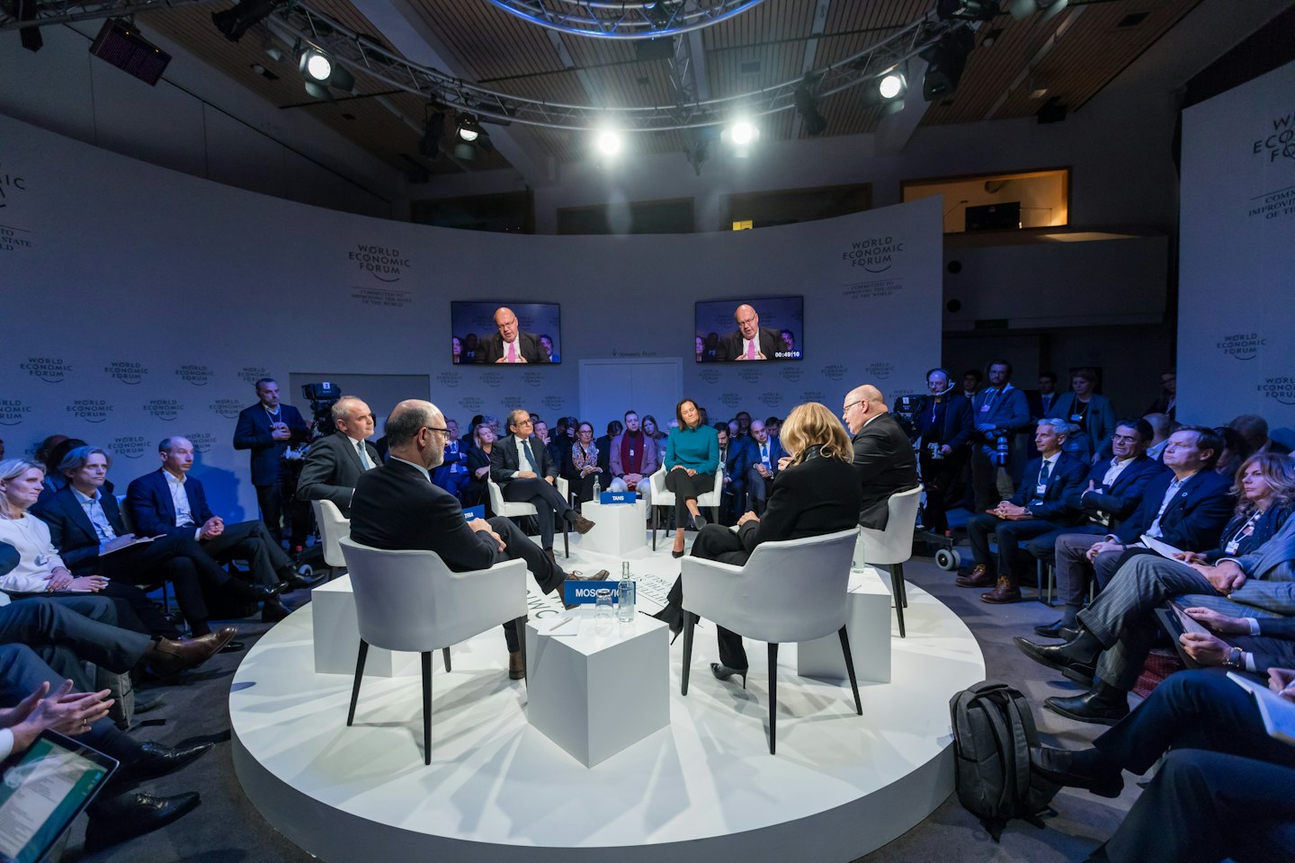 Des professionnels sur une scène circulaire au Forum Économique Mondial.